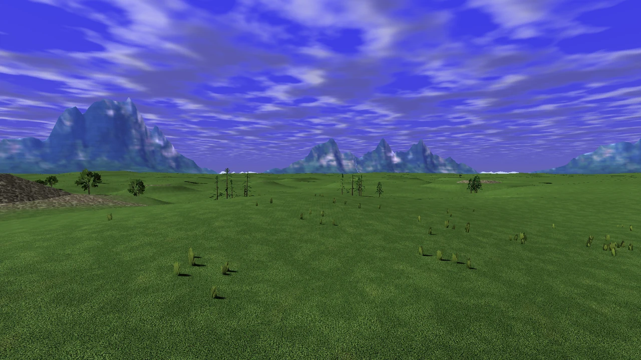 Rolling green ground with scattered vegetation beneath mountains and a blue sky.